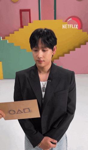 a man in a suit holds a card that says oad on it