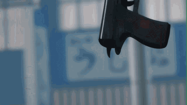 a gun is hanging from a pole with a sign in the background that says ' u '