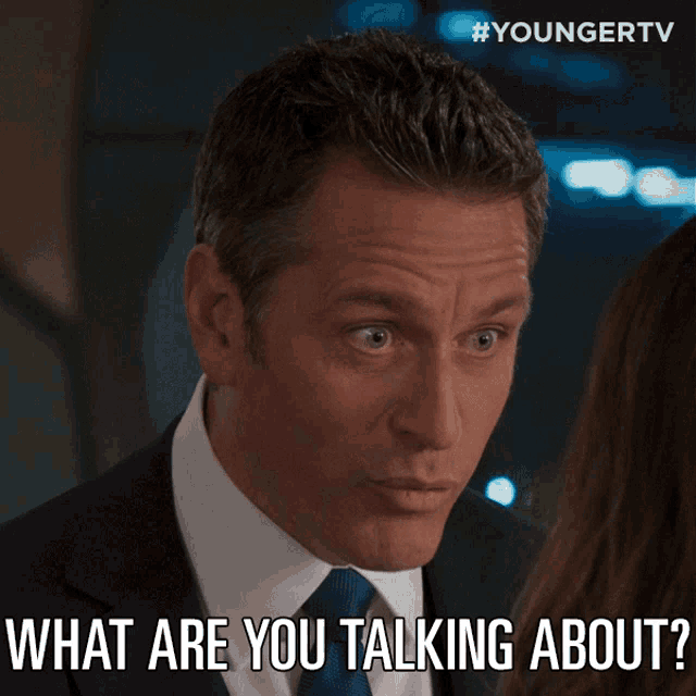 a man in a suit and tie says " what are you talking about " to a woman