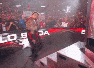 a man in a wrestling ring with a sign that says " keep calm and carry on "