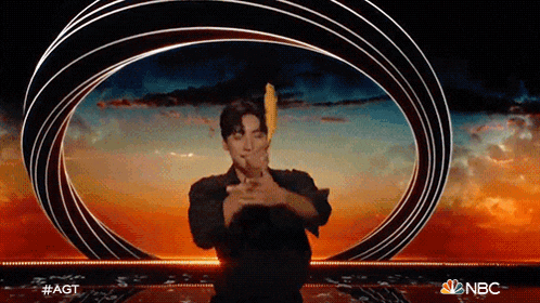 a man is standing in front of a nbc logo on a stage