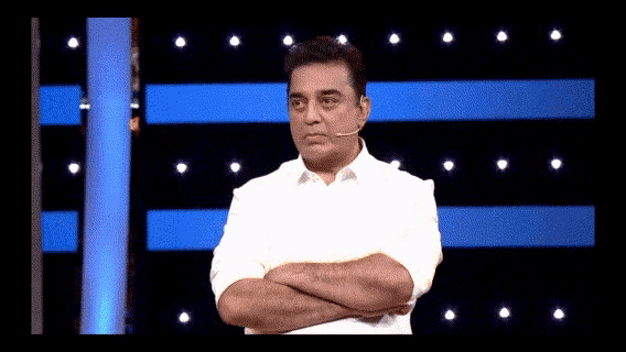 a man with his arms crossed is standing in front of a blue background