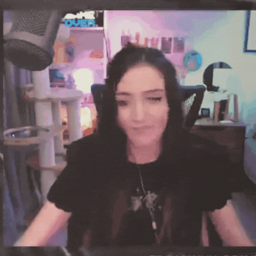 a woman in a black shirt is sitting in front of a computer