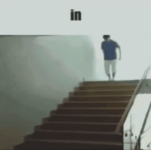 a man is walking up a set of stairs with the word in behind him