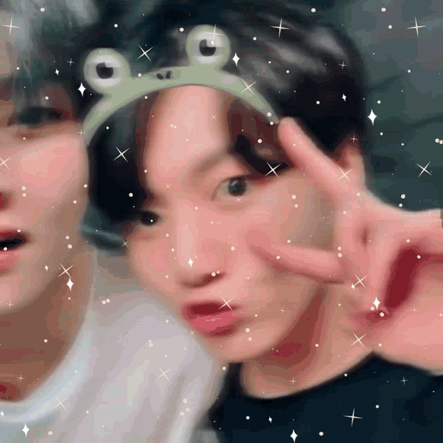 a man wearing a frog headband giving a peace sign