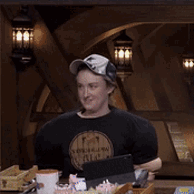 a man is sitting at a table with his hands on his stomach