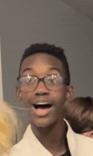 a young man wearing glasses is making a funny face .