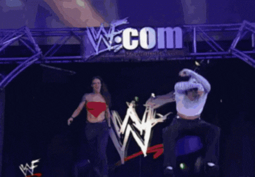 a couple of people are dancing in front of a w.com sign