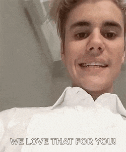 justin bieber is smiling and saying `` we love that for you '' while wearing a white shirt .
