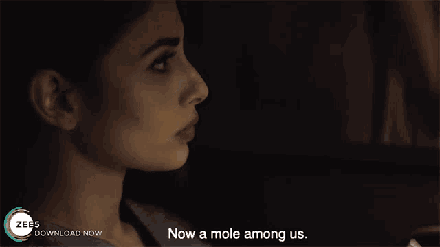 a woman in a dark room with the words now a mole among us