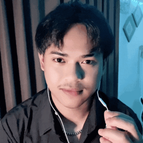 a young man wearing ear buds holds a fork in front of his mouth