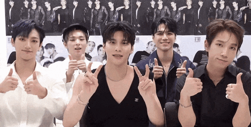 a group of young men are standing next to each other and giving a thumbs up .