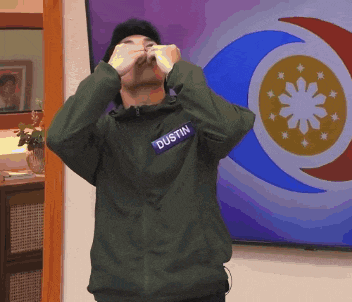 a man wearing a name tag that says dustin covering his eyes