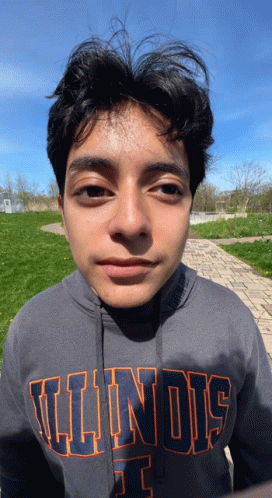 a young man wearing a gray illinois sweatshirt looks at the camera