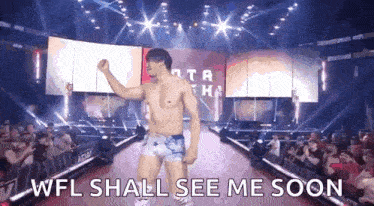 a man without a shirt is walking down a red carpet with the words wfl shall see me soon written on it .
