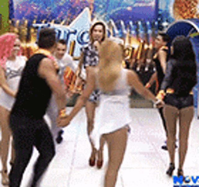 a group of people are dancing on a dance floor in front of a sign that says ' htc ' on it .