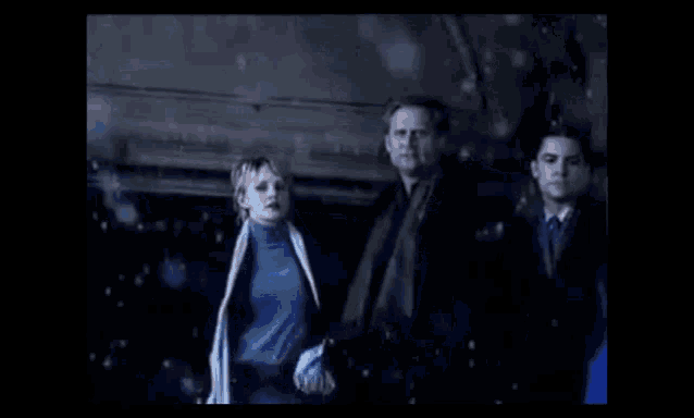 a man and a woman are walking in the dark .