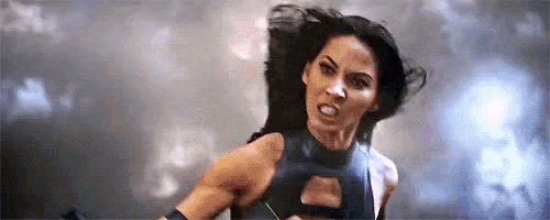 a woman in a superhero costume is fighting a man in a superhero movie .