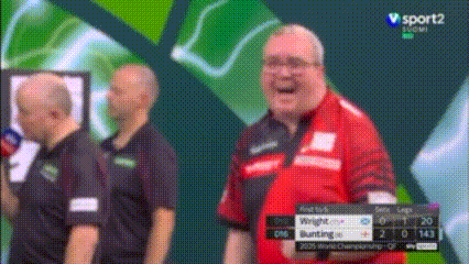 a man in a red shirt is laughing in front of a screen that says v sport2 show