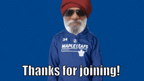 a man wearing a blue maple leafs sweatshirt with his arms in the air