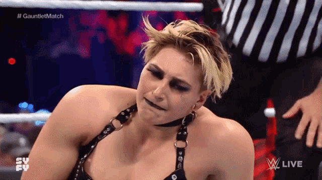 a female wrestler is making a funny face during a wrestling match