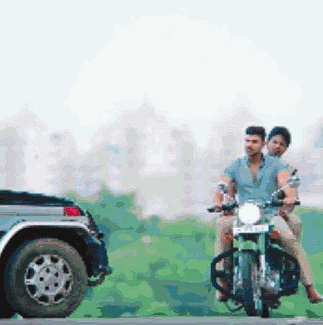 a man and a woman are riding a motorcycle next to a truck .