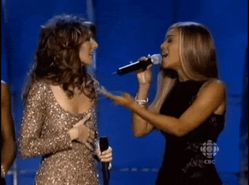 two women singing in front of microphones with a cbc logo in the corner
