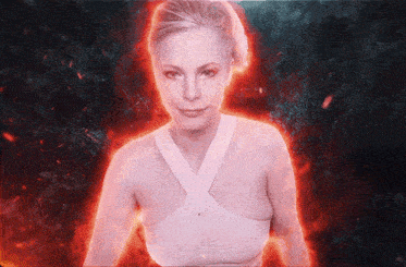 a woman in a white tank top is surrounded by flames