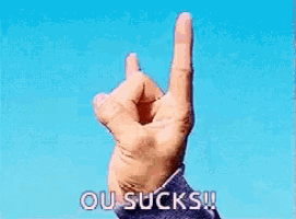 a person 's hand pointing with the words ou sucks written below it