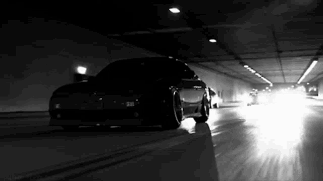 a car is driving through a tunnel at night .