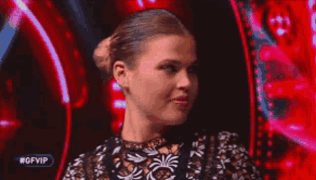 a woman in a black and white lace top is smiling in front of a red background that says #gfvip