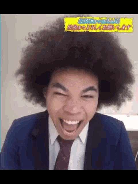 a man wearing a suit and tie has a large afro on his head