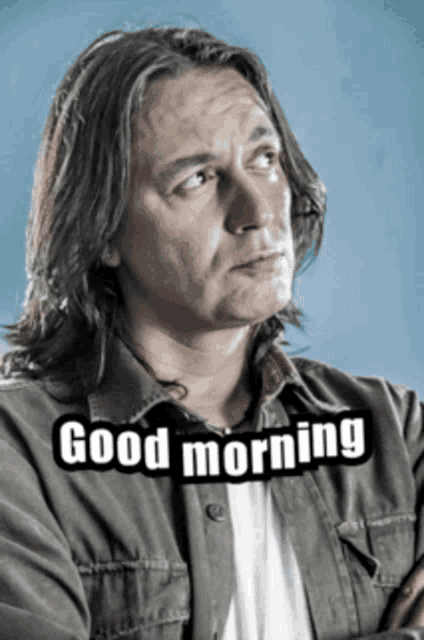a man with long hair is wearing a shirt that says good morning on it