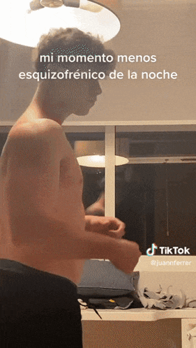 a man without a shirt is standing in front of a window with a tiktok watermark
