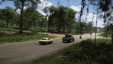 a yellow car is driving down a road next to a truck