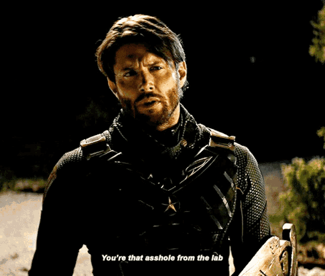 a man with a beard says " you 're that asshole from the lab " in a dark room