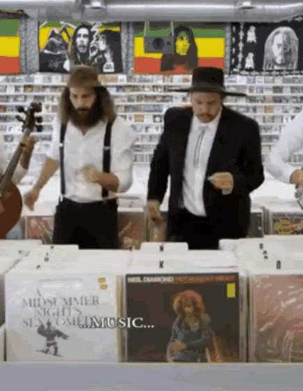 a group of men are standing in front of a display of music