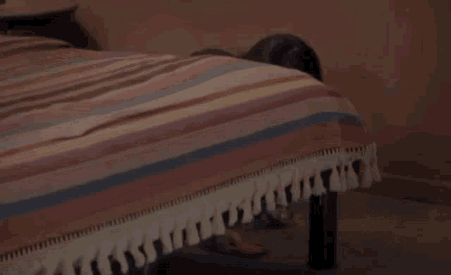 a woman laying on a bed with her head on the blanket