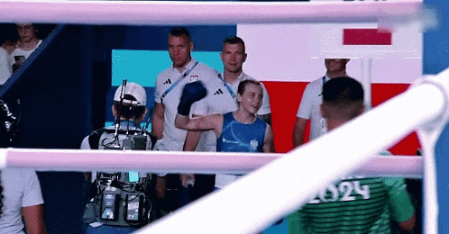 a man in a blue shirt with the number 2024 on his back