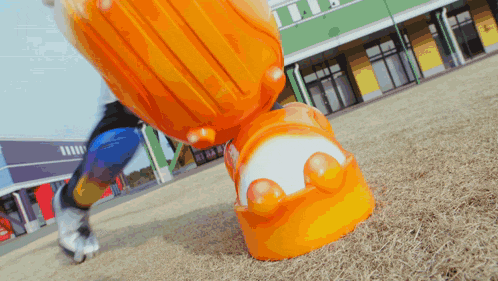 a person is standing next to a large orange and white object