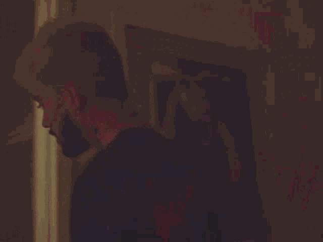 a man with a tattoo on his back walks down a dark hallway
