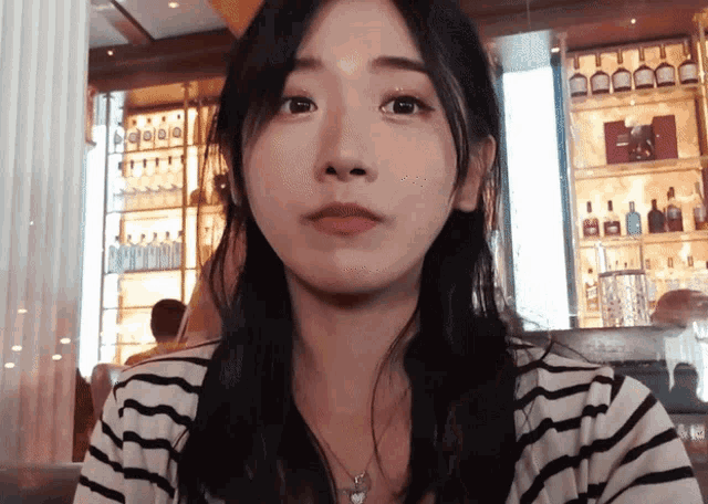a woman wearing a striped shirt is looking at the camera