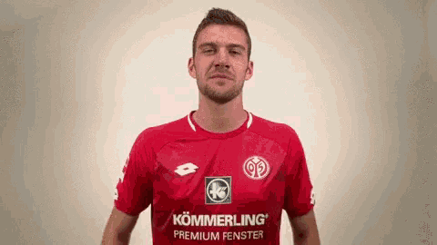 a man wearing a red shirt that says kommerling premium fenster on it
