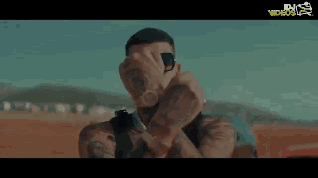 a man wearing sunglasses is standing next to another man in a video for dj videos
