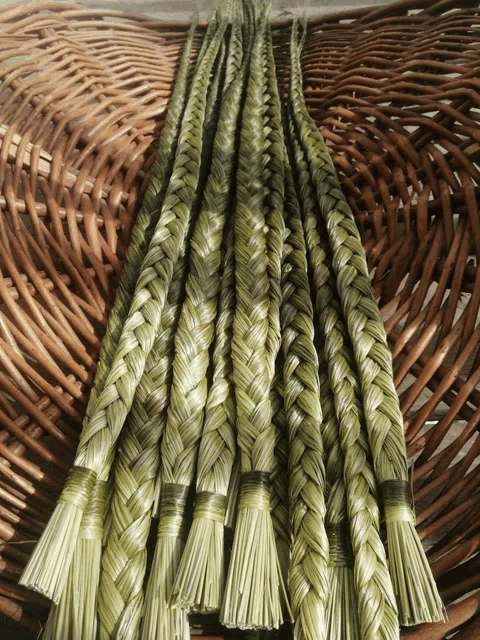 a bunch of green braids are sitting on top of a wicker basket