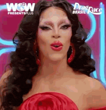 a drag queen is wearing a red dress and red earrings and making a surprised face .
