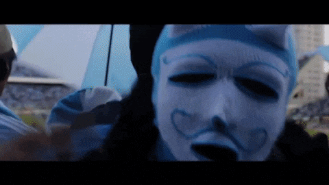 a person wearing a blue and white mask with hearts painted on it