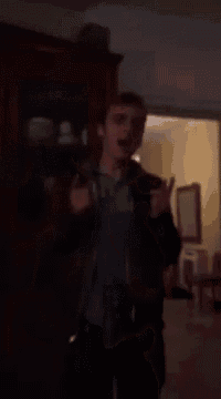 a man is giving a thumbs up in a living room