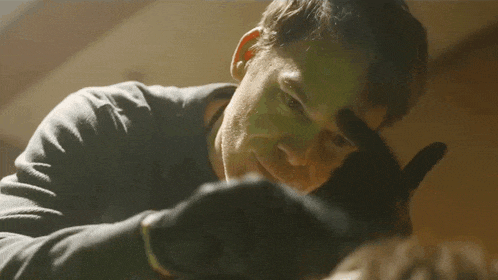 a close up of a man wearing gloves looking at something