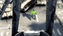 the hulk is walking across a bridge in the city .